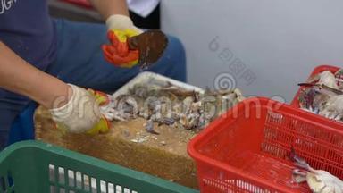 鱼市上的人割小螃蟹。 慢镜头